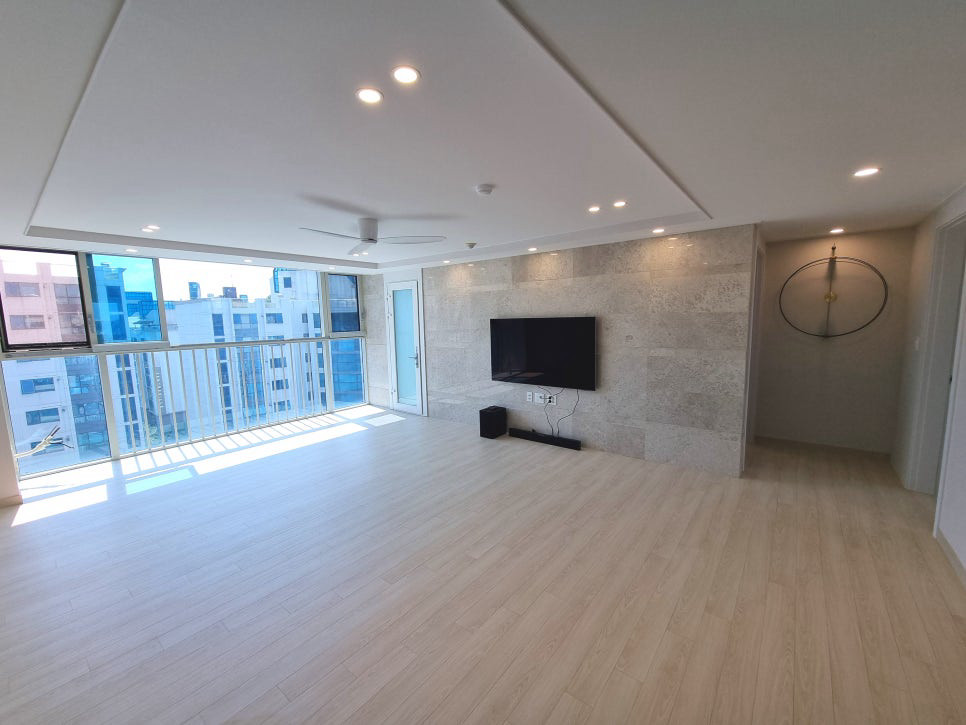 돈의문센트레빌 아파트 인테리어 · 석재 질감 벽과 큰 창이 돋보이는 거실