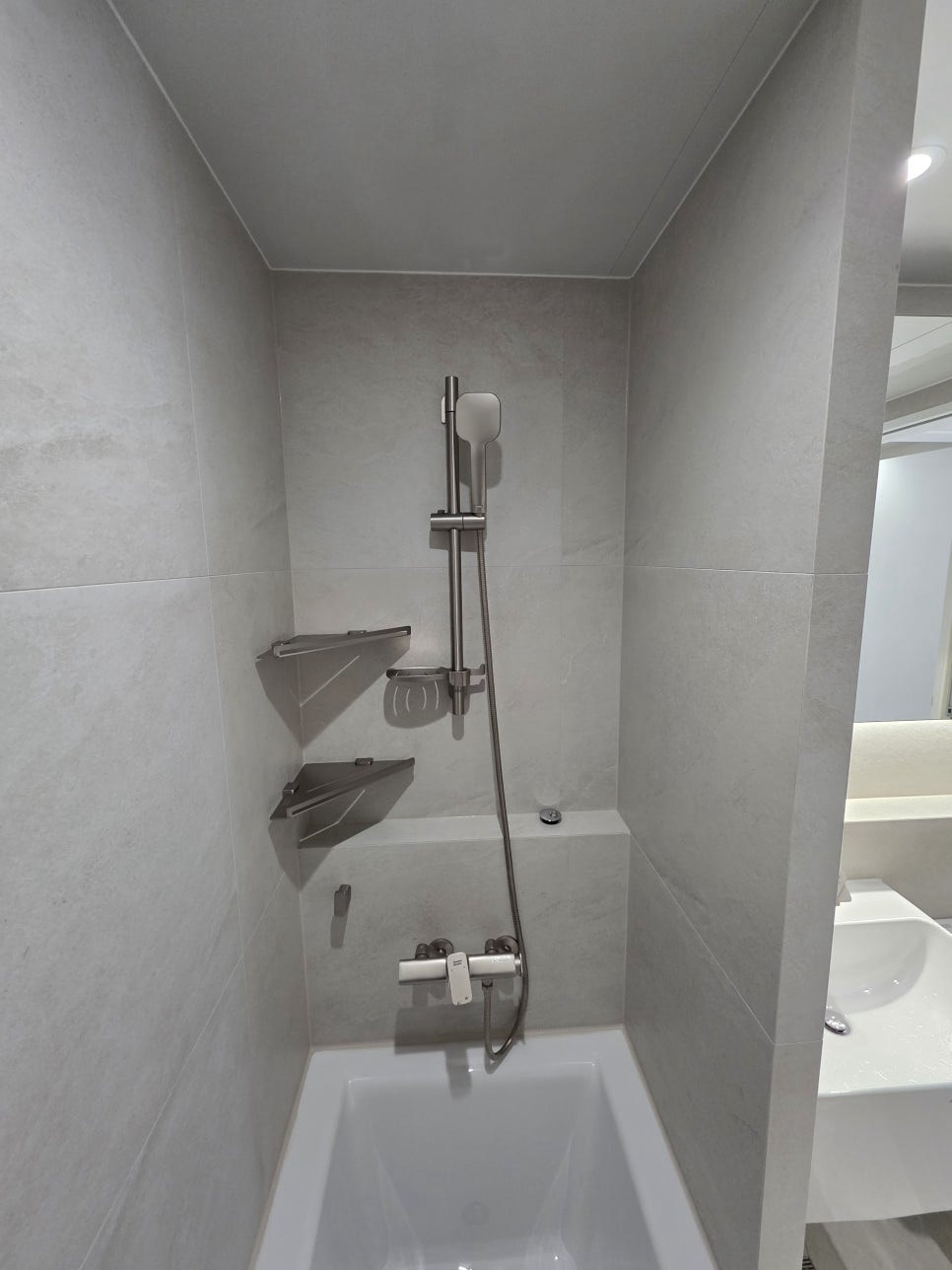 돈의문센트레빌 아파트 인테리어 · 욕조와 회색 타일로 마감한 욕실